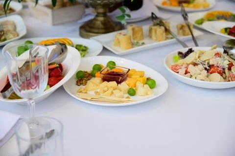 Catering buffet table with cheese platter salad rolls and fresh appetizers .. Stock Photos