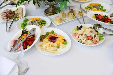 Catering buffet table with cheese platter salad rolls and fresh appetizers .. Stock Photos