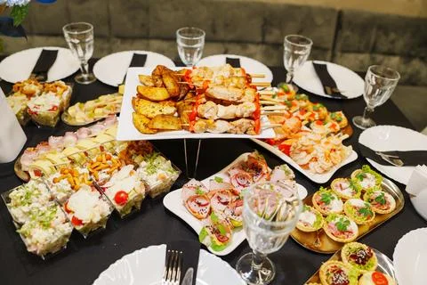 Catering buffet table with delicious chicken skewers and gourmet appetizers Stock Photos