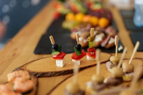 Catering buffet table with various gourmet appetizers on wooden boards. Stock Photos