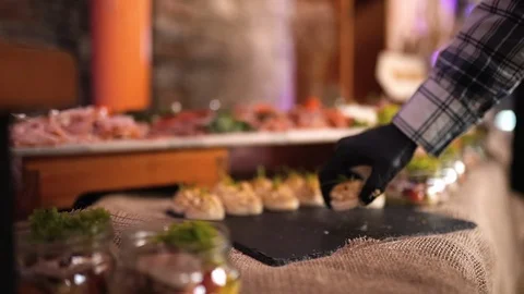 Catering, the waiter puts the snacks on the table 動画素材 124030407