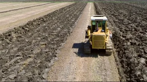 A caterpillar tractor plowing the ground 05 - aerial shot Video stock 40280104