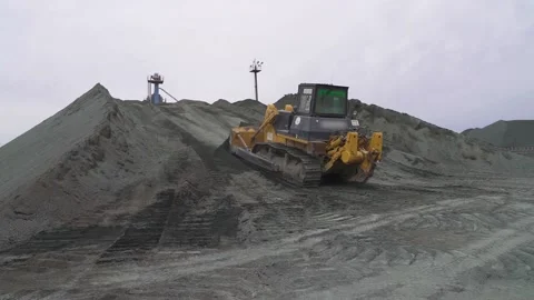 Caterpillars bulldozer climbs a mountain with rubble. Overall plan Stock Footage 145411253