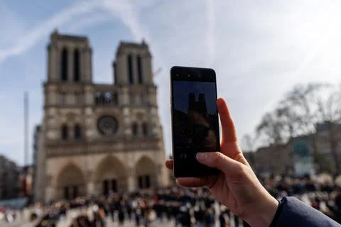 The cathedral is surrounded by a large crowd of people, and the sky is clear Stock Photos
