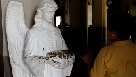 Catholic devotees dip their fingers in holy water at church entrance Video stock 124641081