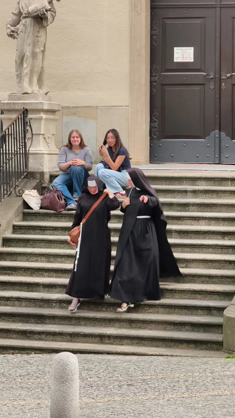 Catholic nuns walking down the steps of Capuchin church in Brno Stock Footage 344642559