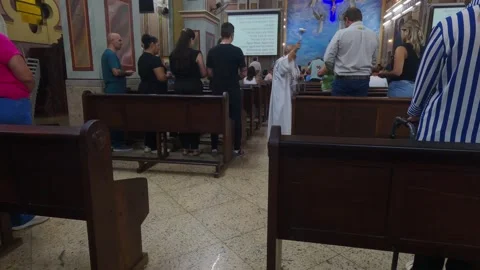 Catholic priest blesses the congregation with holy water Stock Footage 328485909