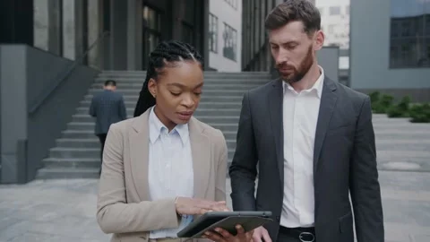 Caucasian and afro-american stylish cooperative colleagues negotiating while Stock Footage 143549341