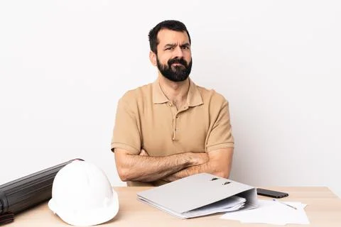 Caucasian architect man with beard in a table with unhappy expression Stock Photos