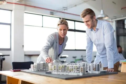 Caucasian architects examining architectural model in office Stock Photos