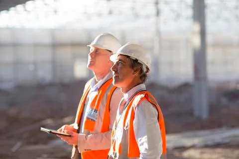 Caucasian architects using digital tablet at construction site Stock Photos