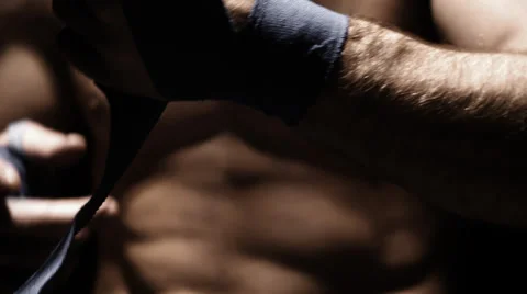 Caucasian athlete methodically wraps his hand with blue cloth. Close up shot. Stock Footage 33867271