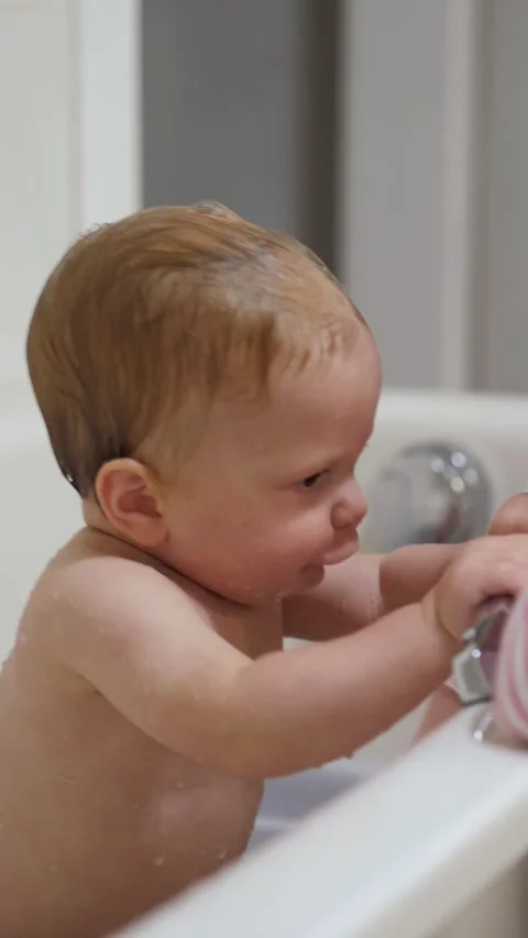 Caucasian baby exploring bath Stock Footage 336189577