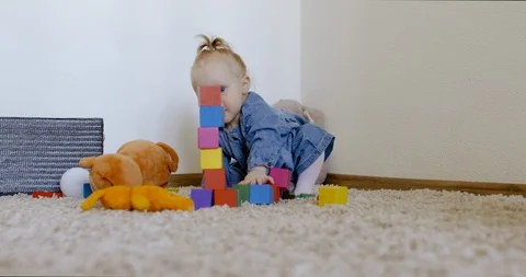 Caucasian baby looking at camera while playing with toys and crawling on the rog Video stock 128504586