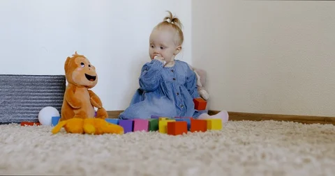 Caucasian baby looking at camera while playing with toys and crawling on the rog Video stock 128507439