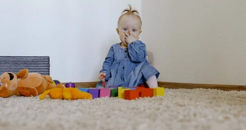 Caucasian baby looking at camera while playing with toys and crawling on the rog Video stock 128507456