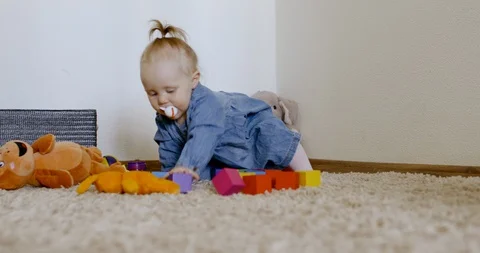 Caucasian baby looking at camera while playing with toys and crawling on the rog Stock Footage 128508821