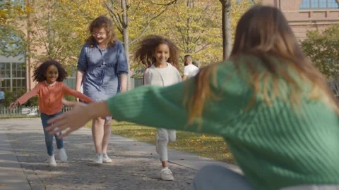 Caucasian babysitter with two african girls walking in autumn park Stock Footage