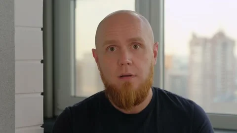 Caucasian, bald guy with a red beard shows the emotion of surprise. Stock Footage 142580872