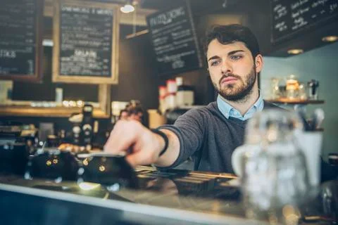 Caucasian barista making coffee in cafe Stock Photos