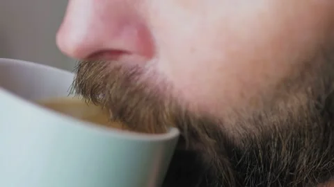 Caucasian bearded man drinking coffee in the kitchen. Video stock 227369370