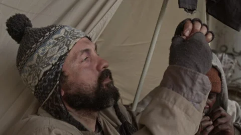 Caucasian Beggar Threading Needle, Black Man Playing Harmonica in Homeless Camp Vidéo 317316588