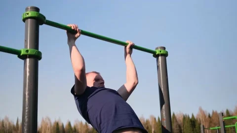 Caucasian blond man pulls himself up on the bar Video stock 153864514