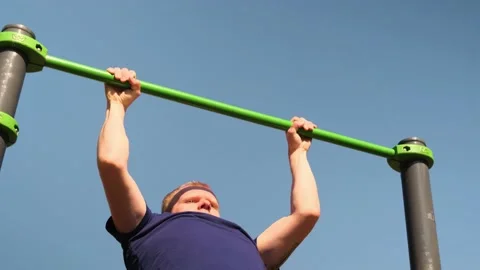 Caucasian blond man pulls himself up on the bar Stock Footage 153864631