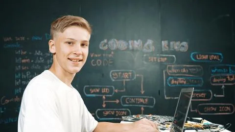 Caucasian boy coding and programing system while looking at camera. Edification. Stock Photos