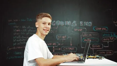 Caucasian boy coding and programing system while looking at camera. Edification. 스톡 사진