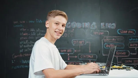 Caucasian boy coding and programming system while looking at camera. Edification Stock Footage 280794865
