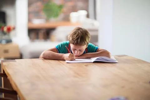 Caucasian boy drawing at table 库存照片