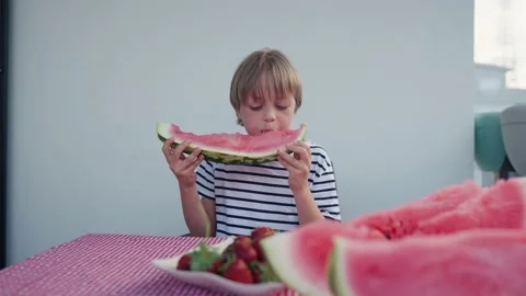 Caucasian boy eats watermelon at home Stock Footage 196568459
