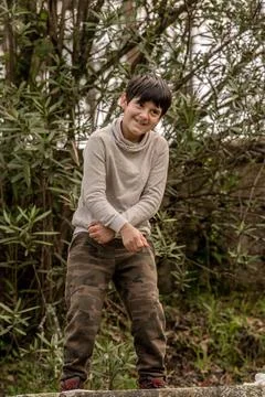 A caucasian boy in the forest with his arms crossed dance and smiling Stock Photos