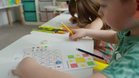 A Caucasian boy performs a task with elements of drawing. Stock Footage 246706499