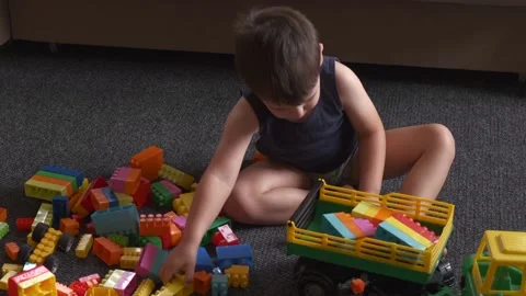 Caucasian boy playing with constructor on the floor picking colorful blocks Stock Footage 152349475