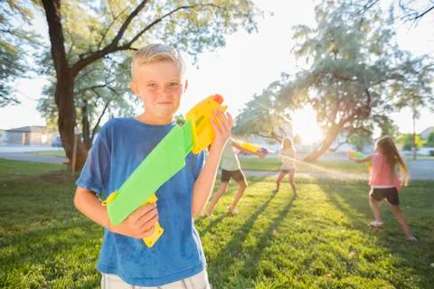 Caucasian boy posing with squirt guns Stock Photos