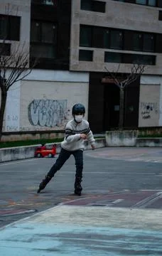 Caucasian boy practises roller skating in a city park Stock Photos