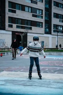 Caucasian boy practises roller skating in a city park Stock Photos
