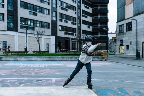 Caucasian boy practises roller skating in a city park Stock Photos