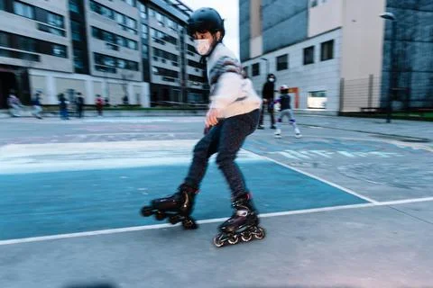 Caucasian boy practises roller skating in a city park Stock Photos