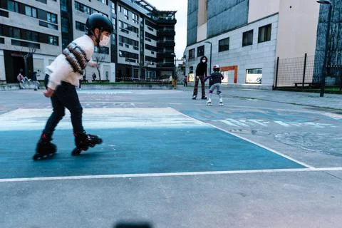 Caucasian boy practises roller skating in a city park Stock Photos
