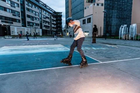 Caucasian boy practises roller skating in a city park Stock Photos