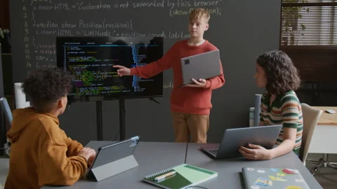 Caucasian Boy Presenting Coding Project on Screen to Classmates at Lesson Stock Footage 318715723