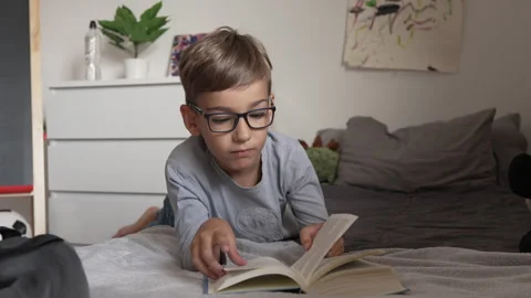 Caucasian boy pupil student read book at home study learn slow motion Stock Footage 249808889
