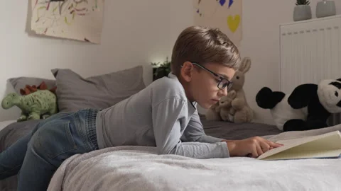 Caucasian boy pupil student read book at home study learn slow motion Stock Footage 249809064