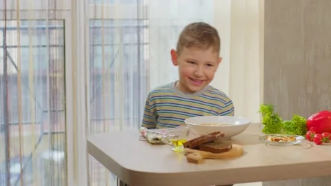 A Caucasian boy runs up to the table where lunch is waiting for him. Stock Footage 237098285