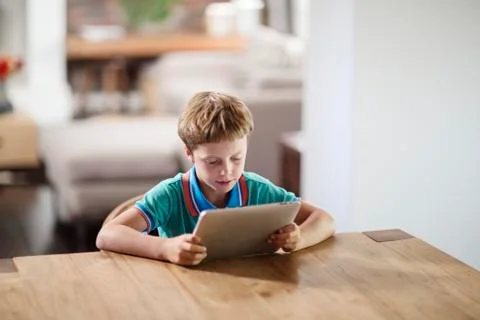 Caucasian boy using digital tablet at table 스톡 사진