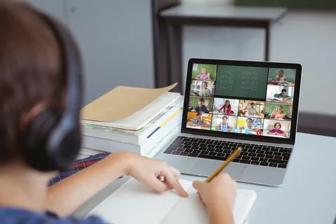 Caucasian boy writing maths problems while studying online over video call on Foto stock