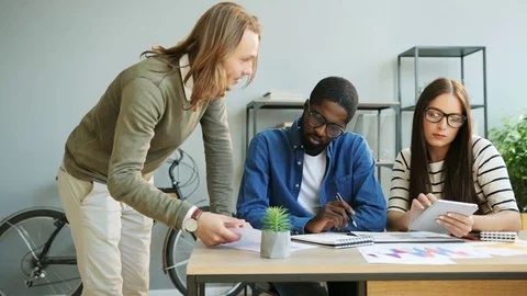 Caucasian business man and woman, african man working together on some big Stock Footage